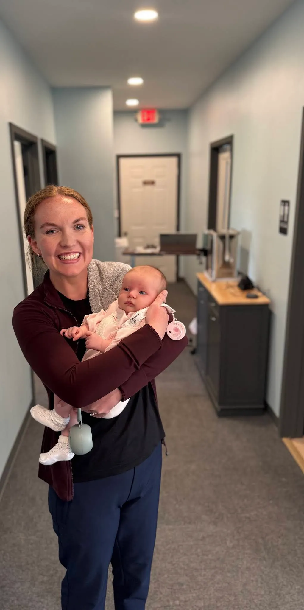 A Beyond Physical Therapy clinician holding a baby in the Spring Hill clinic.